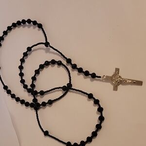 Black beaded rosary. It has a crucifix on the back and an image of San Benito